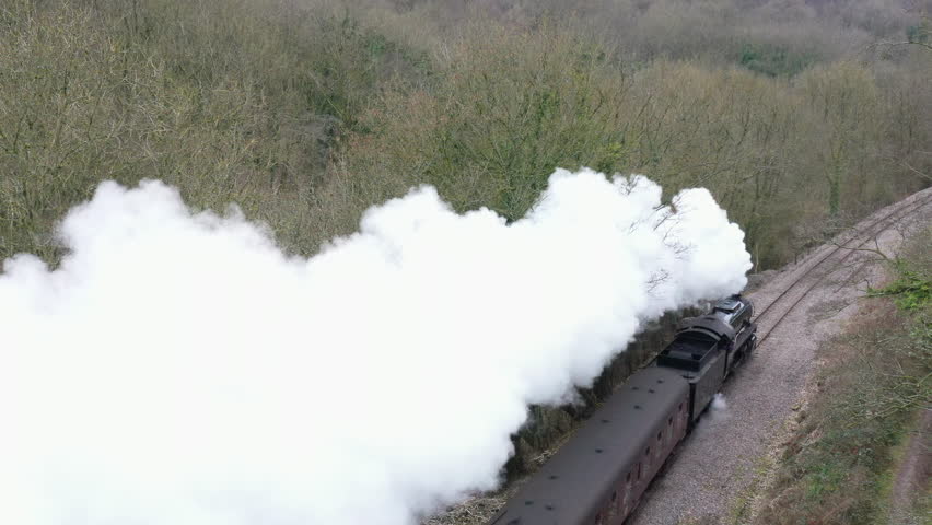 Aerial view of steam train from drone traveling through English countryside. Tourist attraction near Manchester in winter landscape England UK 4K
