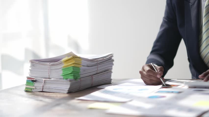Businessman office workers holding are arranging documents of unfinished documents on office desk,Stack of business paper, document management, Businessman examining documents. Royalty-Free Stock Footage #1100328697