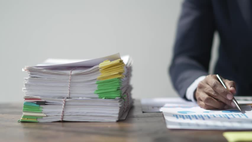 Businessman office workers holding are arranging documents of unfinished documents on office desk,Stack of business paper, document management, Businessman examining documents. Royalty-Free Stock Footage #1100328699