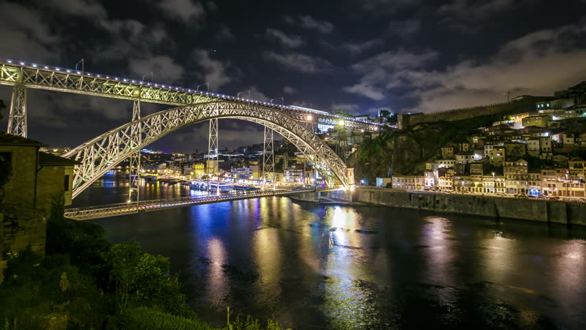 The Dom Luis I Bridge illuminated at night timelapse panorama. Metal arch bridge that spans the Douro River between the cities of Porto and Vila Nova de Gaia, Portugal
