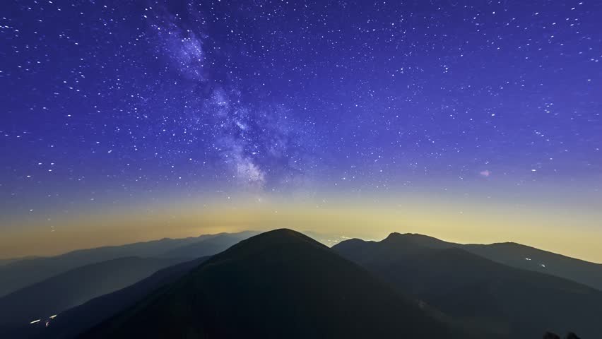  From night to day.Sky during a starry night with a milky galaxy of stars in the mountains. | Shutterstock HD Video #1100335001