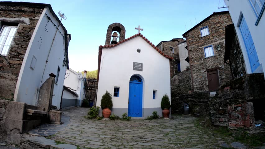 SLOW MOTION SHOT The picturesque little schist village of Piodão clings to a steeply terraced mountainside deep within the foothills of the Serra de Açor range in central Portugal. Saint Peter Chapel.
