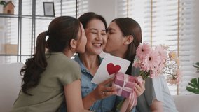 Mother's day two grown up child cuddle hug give flower gift box red heart card to mature mum. Love kiss care mom asia middle age adult three people sitting at home sofa happy smile enjoy family time. - Powered by Shutterstock - Get 15% off with code: PIKWIZARD15