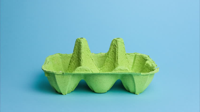 Cute easter eggs with funny faces in green box isolated on blue background. Happy easter concept. Stop motion easter animation.