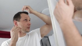 middle aged man with alopecia looking at mirror, hair loss concept - Powered by Shutterstock - Get 15% off with code: PIKWIZARD15