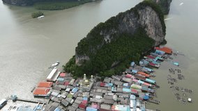 Aerial drone view flying over the floating fishing village at Ko Panyi (or Koh Panyee) one of travel destination in Phang Nga Bay, Phang Nga province, Thailand. 4K footage video