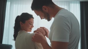 Family embracing cute infant child boy with love in the room. Smiling caucasian mother holding sleeping newborn baby with her husband standing beside them. Slow-motion - Powered by Shutterstock - Get 15% off with code: PIKWIZARD15