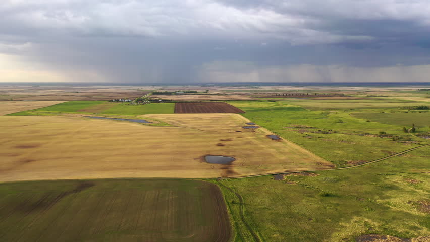 Aerial view of farmland in North Dakota, USA. American countryside, rural scenery at sunset, sunny with rain in the background
