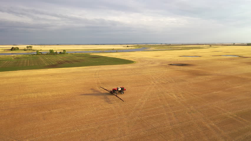 Aerial view of farmland in North Dakota, USA. American countryside, farming vehicles in the field