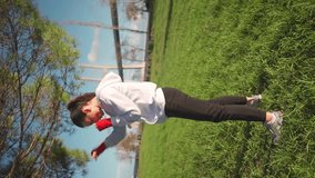 Woman shadow boxing with her hands wrapped in red boxing tapes in park. Middle age female athlete fighter training outside dressed hoodie. Vertical video. Athletic female fighter training outside