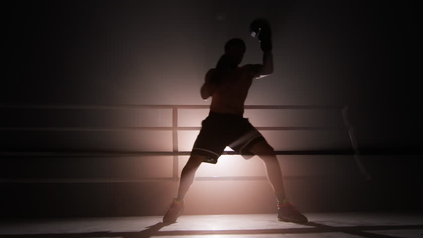 Close-up view of well-trained athlete with lean body warming up before a sparring. Portrait of unrecognizable man wearing boxing gloves and practicing a knock. High quality 4k footage | Shutterstock HD Video #1100349093