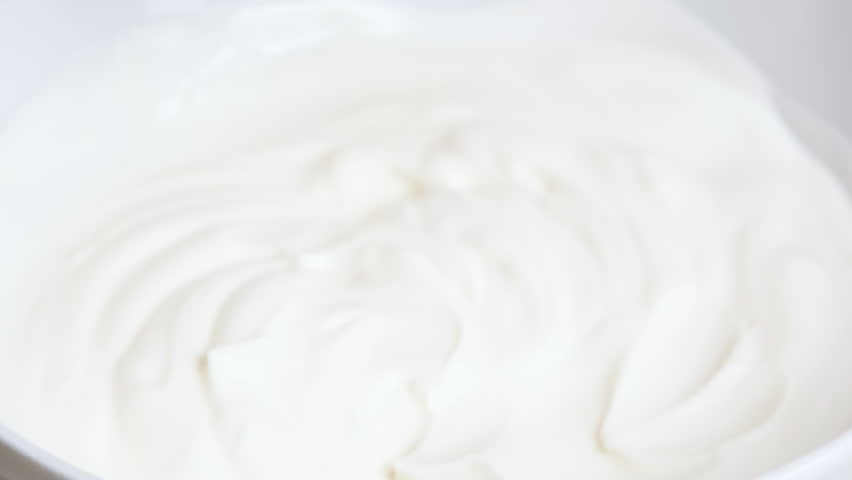 Strawberry dipping in cream, hand dipping berries in milk yogurt, fresh organic dessert. 4K resolution summer food video. Concept of: healthy eating, diet, wellness and strawberries