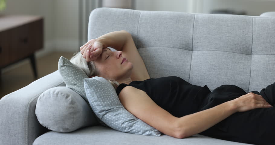 Tired woman falls asleep on sofa in living room, feels unmotivated, relaxing alone at home, spend weekend leisure, day off sleeps, without motivated to do things. Rest, lack of energy, fatigue relief Royalty-Free Stock Footage #1100353683