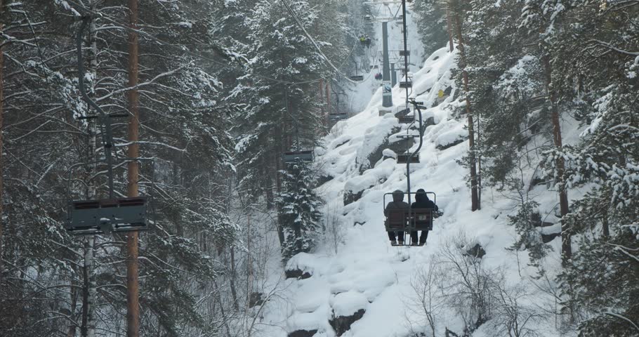 Tourists climb up the mountain using a suspended cable lift. The town of Belokurikha, Siberia. Hand held.