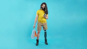 Man with prosthetic leg using the mobile holing shopping bags - Powered by Shutterstock - Get 15% off with code: PIKWIZARD15