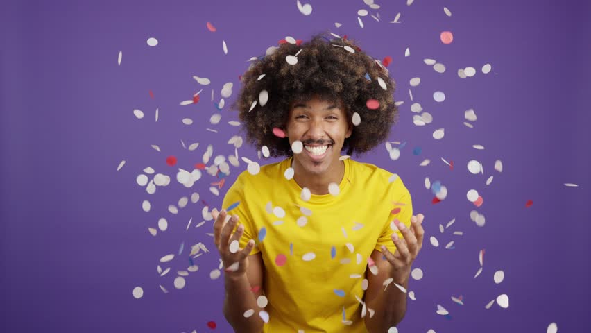 Cool african man surrounded by confetti flying in the air