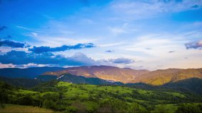 Multicolored sky with clouds and sunset light over the Rhodope Mountains with a intermountain village