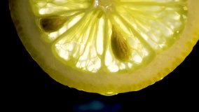 half of a fresh lemon cut into slices against a black background, with large bones, macro - Powered by Shutterstock - Get 15% off with code: PIKWIZARD15