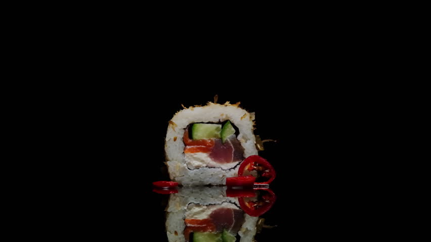 Spicy sushi roll burning with flames rotates on black background on mirrored reflective table close-up. Sushi menu, Japanese food, Asian cuisine. Royalty-Free Stock Footage #1100365453