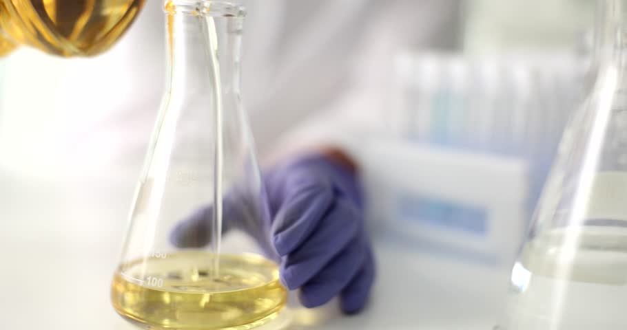 Scientist hand pours high viscosity petroleum yellow lubricating oil into test tube in laboratory Royalty-Free Stock Footage #1100365723