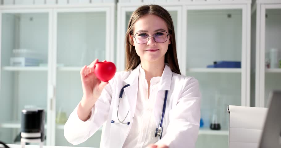 Female doctor cardiologist therapist holds red toy heart in hands closeup Royalty-Free Stock Footage #1100365849