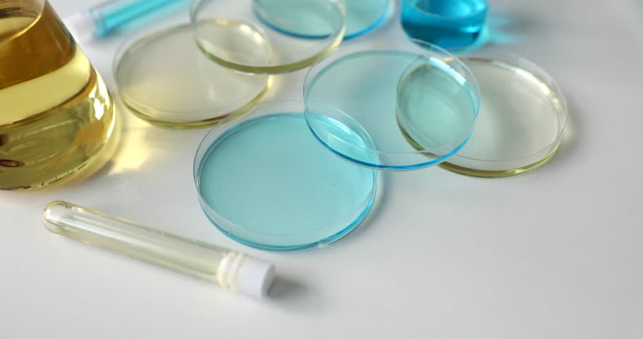 Various glassware and test tubes with light blue liquid and oil in laboratory | Shutterstock HD Video #1100365889