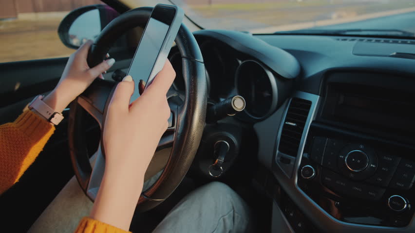 Hands of unrecognizable woman driver using mobile phone while driving car, distracted driving, don't text and drive Royalty-Free Stock Footage #1100368047