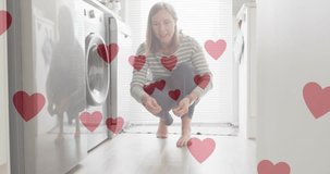 Animation of heart emojis over happy caucasian woman with dog. Love, romance and celebration concept digitally generated video.
