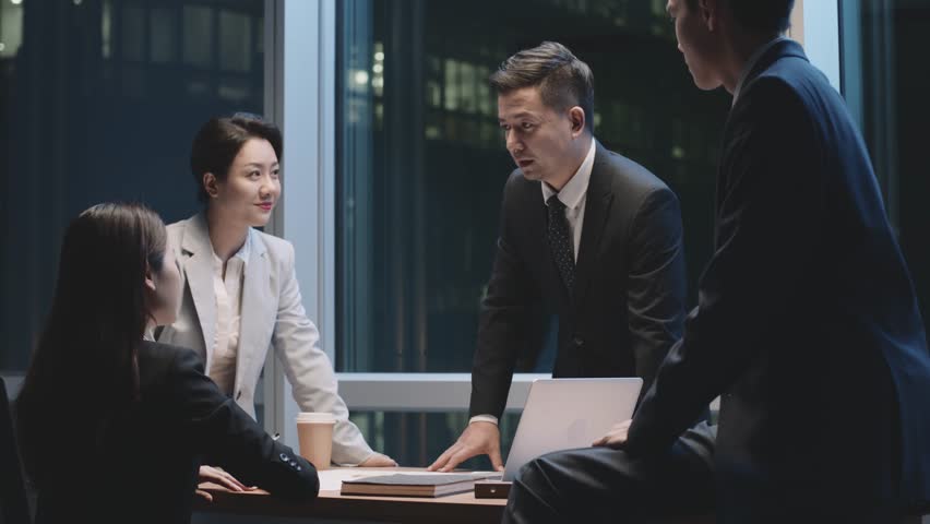 Team of asian business people men and women working late meeting in office at night | Shutterstock HD Video #1100384303