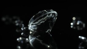 A slow turning sparkling diamond on a dark shiny surface to indicate luxury or wealth or as a gift for special occations like weddings valentines day. - Powered by Shutterstock - Get 15% off with code: PIKWIZARD15