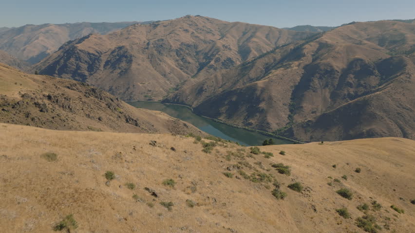 Aerial coming over hill to reveal Snake River and Hells Canyon Gorge