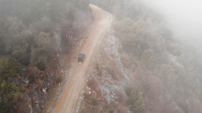 Aerial Drone Shot Tracking follow Car 4x4 foggy forest mountain