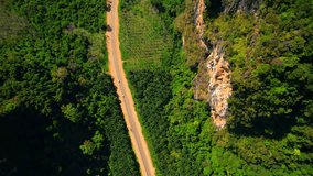 Beautiful Limestone mountains roads, palm and coconut farming areas. Krabi, Thailand. Epic asphalt roads. Green tropical rainforest. travel and tourism concept. Stunning stock video footage. 4K Drone
