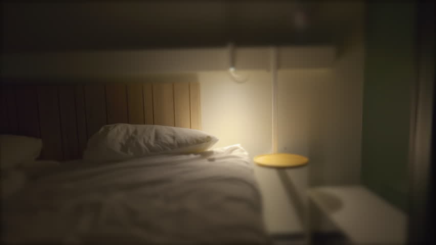 Person prepares to go to bed and sleep. Man lays down in bed and turns off night stand besides bed Royalty-Free Stock Footage #1100394599