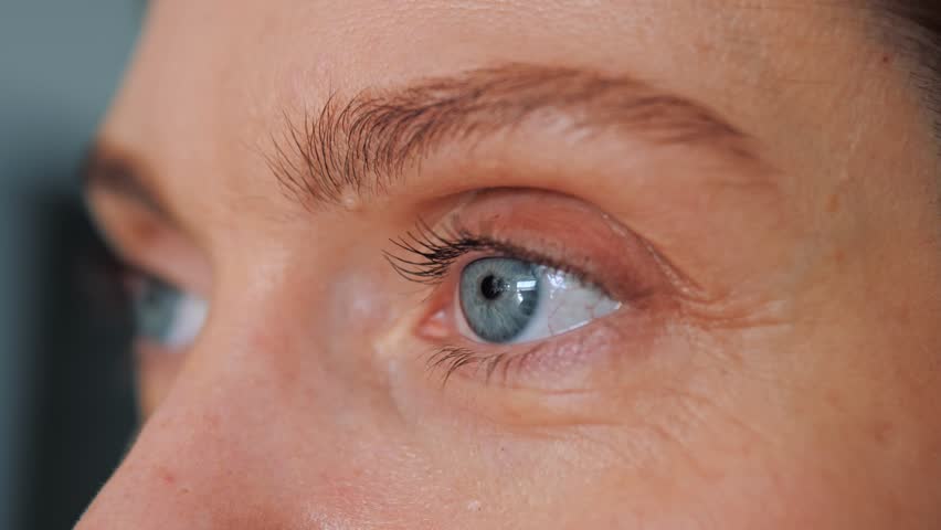 Close up of Woman's face. Beautiful woman opening her beautiful blue eyes. Caucasian young adult female model with blue, green, grey eyes looking to the side. Slow-motion, macro extreme close-up. | Shutterstock HD Video #1100395515
