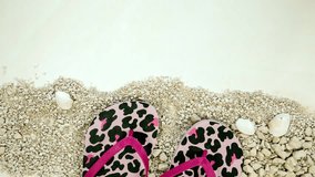 Bright women's flip flops on a colorful yellow background and beach sand moving from left to right top view, pink panther pattern spring,summer concept - Powered by Shutterstock - Get 15% off with code: PIKWIZARD15