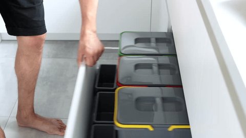Colorful bins for sorting of plastic, paper garbage and organic waste at home. Modern kitchen with a system for sorting waste. Waste Separation Concept. Zero waste. Eco-friendly. 4K footage 库存视频