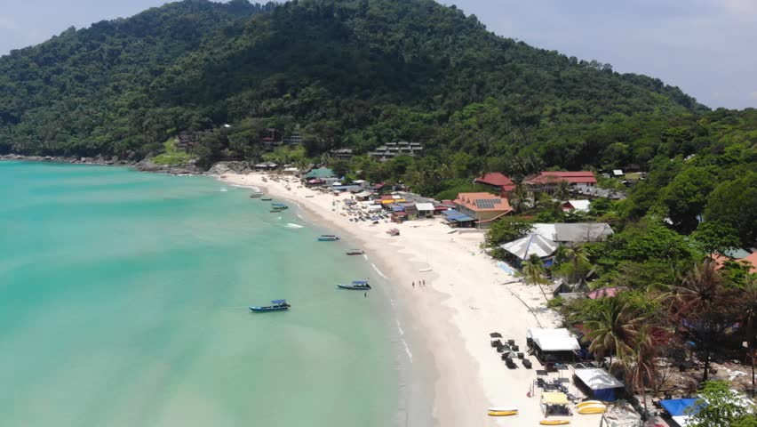 Aerial view of small boats and houses on a tropical beach