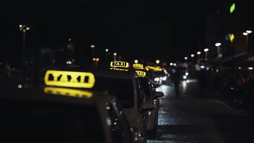 Illuminated Taxi signs on rank at the street at night Royalty-Free Stock Footage #1100399579