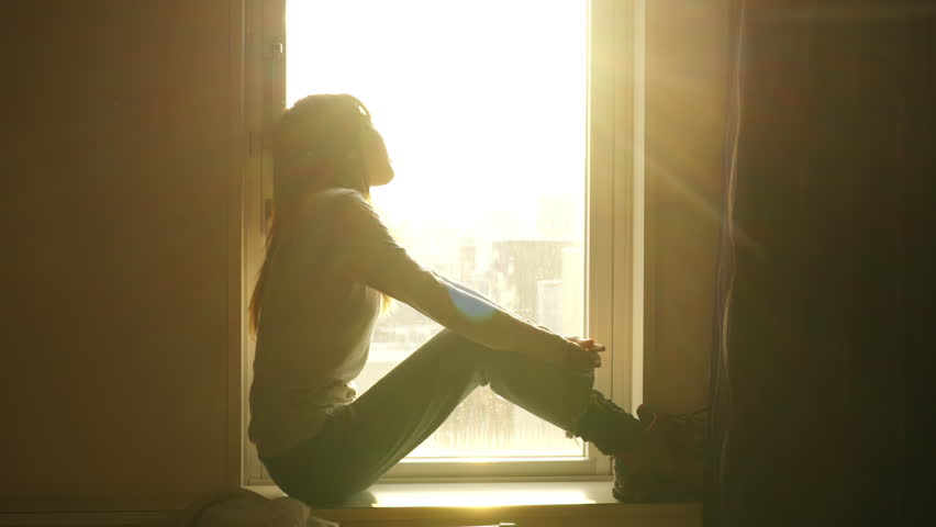 Loneliness Asian woman sitting by the window in bedroom and looking cityscape building covered in snow at winter sunset. Attractive girl resting in hotel room during travel alone on holiday vacation. | Shutterstock HD Video #1100401381
