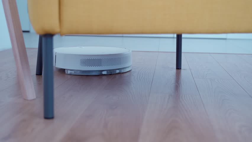 The robot vacuum cleaner cleans the floor in the room. Smart vacuum cleaner cleans the floor. 4k | Shutterstock HD Video #1100402375