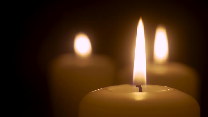 Close up view of igniting candles in dark. Cozy macro home interior, burning candles flame. Lifestyle remembrance celebration religious | Shutterstock HD Video #1100403859