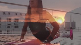 Animation of glowing sunset light over biracial woman practicing yoga. Health and fitness, active lifestyle concept digitally generated video.