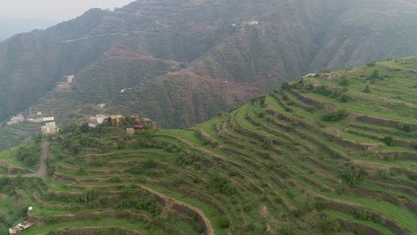 Aerial view of the mountainous landscape and terraces near Rijal Village Almaa is a village located in the Asir region of Saudi Arabia. Royalty-Free Stock Footage #1100406417
