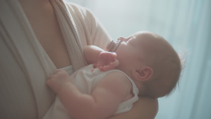 Baby sleeping peacefully in mothers arms, loving mother holding infant caring for sleepy toddler at home 4k | Shutterstock HD Video #1100407479
