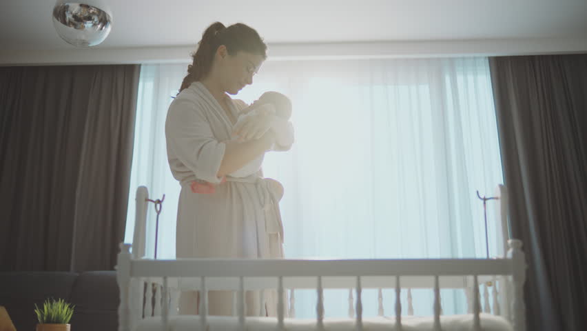 Slow-motion shot of a beautiful young caring mother putting her newborn baby boy in crib. Happy motherhood concept Royalty-Free Stock Footage #1100407485