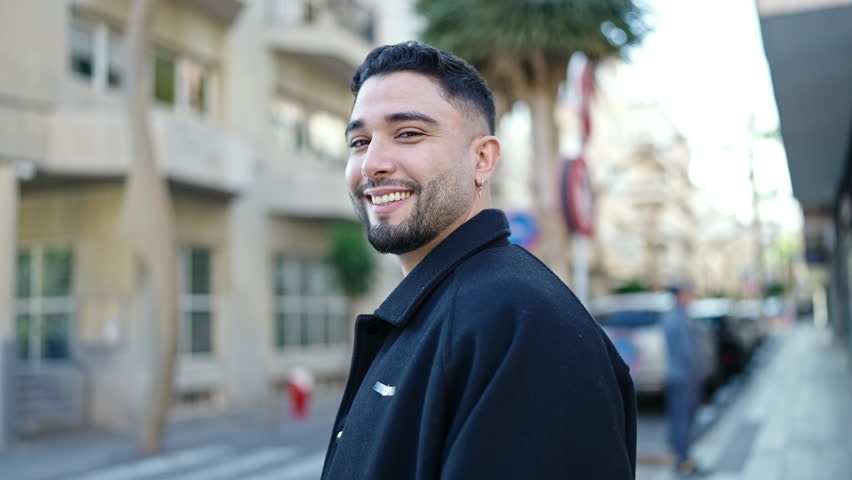 Young arab man smiling confident standing at street