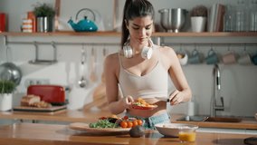 Video of fitness woman making a healthy poke bowl in the kitchen at home.