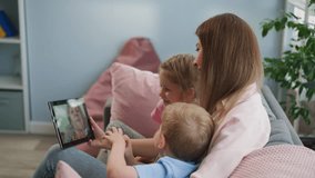 Children feel happy to see beloved granny on video call looking at screen of tablet and talking. Woman and siblings enjoy communication closeup - Powered by Shutterstock - Get 15% off with code: PIKWIZARD15