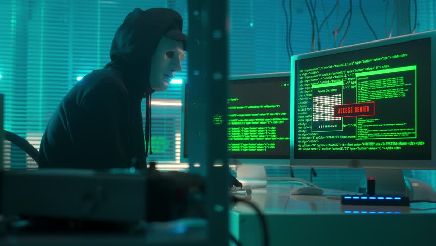 Hacker in a white mask is typing on a computer keyboard and cracking a password. A man in a black hoodie and gloves. A green line of codes appears on the screen. Access denied, then to access granted. Royalty-Free Stock Footage #1100412739
